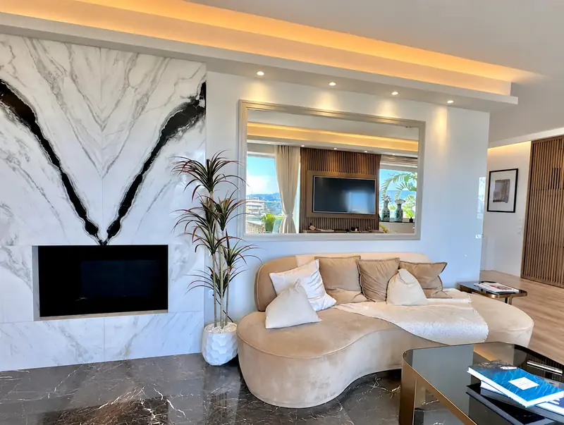 The Penthouse Apartment lounge with a sculptural marble fireplace and curved sofa
