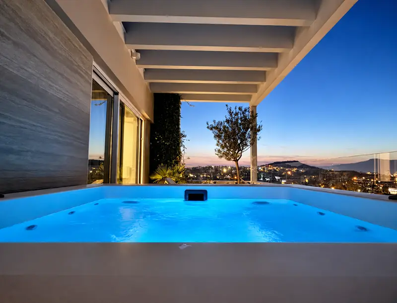 An illuminated Jacuzzi with Athens city lights beyond